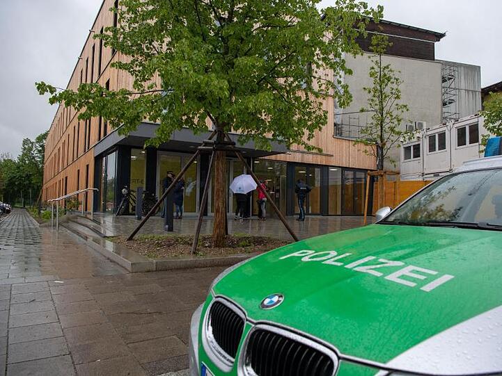 Ein Polizeiauto steht nach einer Bombendrohung vor einer Münchner Schule. Foto: Lino Mirgeler