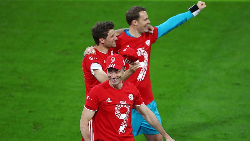 Robert Lewandowski (vorne), Thomas Müller (M) und Torwart Manuel Neuer feiern gemeinsam.