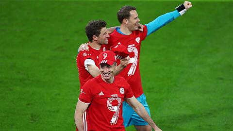 Robert Lewandowski (vorne), Thomas Müller (M) und Torwart Manuel Neuer feiern gemeinsam.