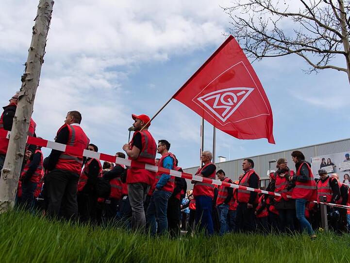 Beschäftigte des Autozulieferers Bosch stehen bei einer Demonstration mit Fahnen der IG-Metall. Foto: Nicolas Armer