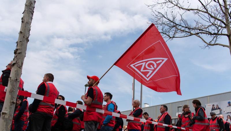 Beschäftigte des Autozulieferers Bosch stehen bei einer Demonstration mit Fahnen der IG-Metall. Foto: Nicolas Armer Beschäftigte des Autozulieferers Bosch stehen bei einer Demonstration mit Fahnen der IG-Metall. Foto: Nicolas Armer