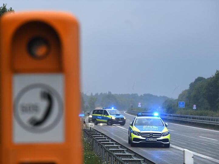 Polizeifahrzeuge mit eingeschaltetem Blaulicht fahren zur Unfallstelle.