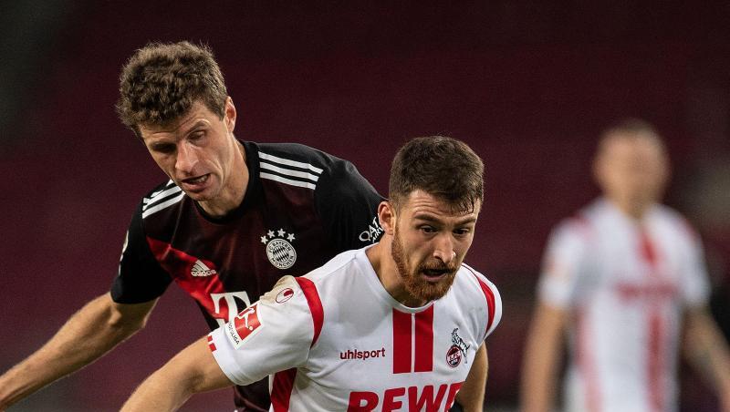 Kölns Salih Özcan (r) und Bayerns Thomas Müller kämpfen um den Ball.