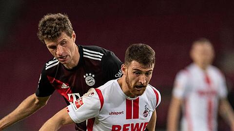 Kölns Salih Özcan (r) und Bayerns Thomas Müller kämpfen um den Ball.