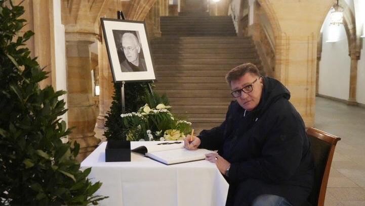 Vinzent Fernandez trägt sich in das Kondolenzbuch für Franz Beckenbauer im Rathaus ein.