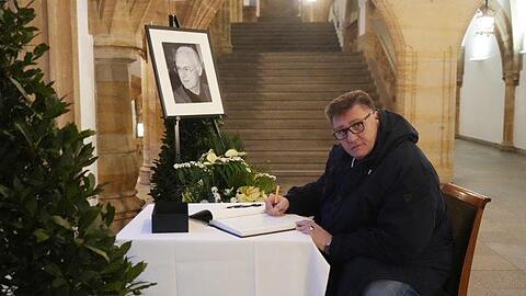Vinzent Fernandez trägt sich in das Kondolenzbuch für Franz Beckenbauer im Rathaus ein.