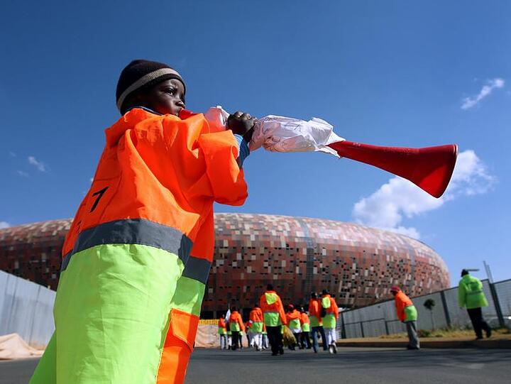 Ein Kind bläst vor dem Soccer City Stadio in Johannesburg in eine Vuvuzela.