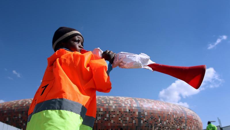 Ein Kind bläst vor dem Soccer City Stadio in Johannesburg in eine Vuvuzela. Ein Kind bläst vor dem Soccer City Stadio in Johannesburg in eine Vuvuzela.