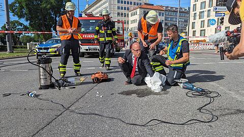 Ein Klimaaktivist hat sich mit Zement an einer Fahrbahn auf dem Münchner Karlsplatz (Stachus) fixiert. Die Polizei war dort am Freitag wegen einer Blockadeaktion der Gruppe Letzte Generation im Einsatz.