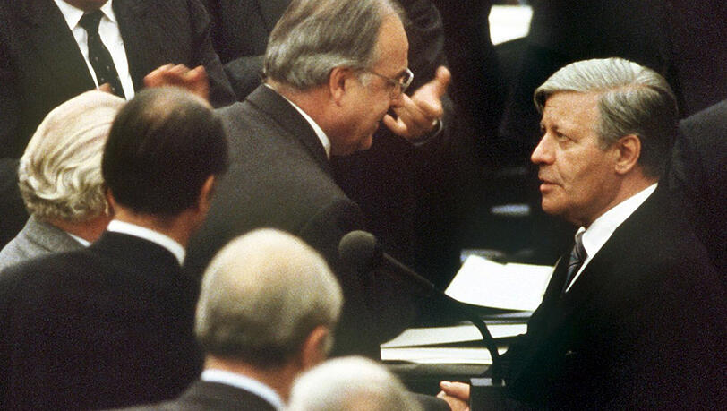 1. Oktober 1982: Machtwechsel in der Bundesrepublik. Der gestürzte Bundeskanzler Helmut Schmidt (r, SPD) beglückwünscht nach einem konstruktiven Misstrauensvotum seinen Nachfolger Helmut Kohl (M) zu dessen Wahl.