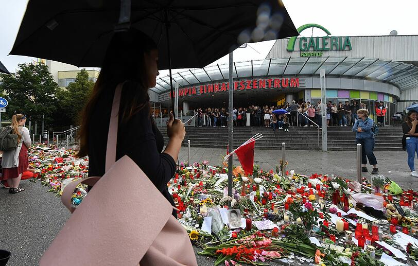 Anteilnahme vor dem OEZ: Am Montag nach der Schießerei trauern Münchner vor dem Einkaufszentrum und gedenken mit Bildern, Blumen und Schildern.