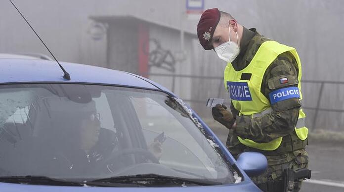 Ein Polizist kontrolliert während einer Straßenkontrolle ein Fahrzeug im Dorf Zvonijov bei Jihlava.