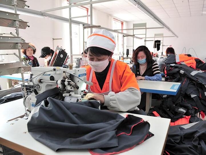 Frauen verarbeiten Kleidung im chinesischen Chengde. Weltweit arbeiten Frauen mehr als Männer.