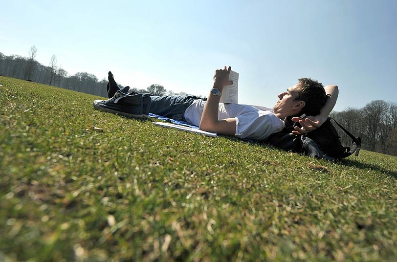 In den Münchner Parks, wie hier im Englischen Garten, lassen sich die Menschen die Sonne auf den Bauch scheinen.