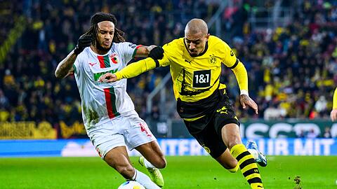 Dortmunds Donyell Malen (r) in Aktion gegen Augsburgs Kevin Mbabu (l).