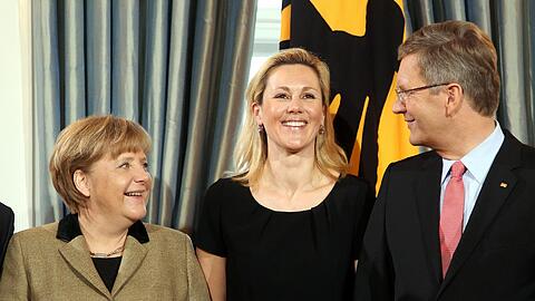 Bundespräsident Christian Wulff (r) und seine Ehefrau Bettina begrüßen am Donnerstag (12.01.2012) während des Neujahrsempfangs im Schloss Bellevue in Berlin, Bundeskanzlerin Angela Merkel (CDU). Traditionell lädt das Staatsoberhaupt verdiente Bürger und Vertreter des öffentlichen Lebens, Politik, Kultur und Sport zum Neujahrsempfang in seinen Amtssitz.