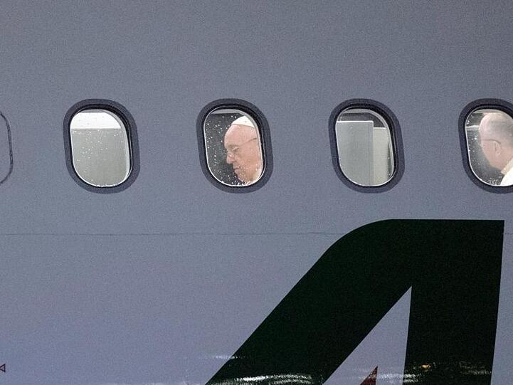 Papst Franziskus in einem Flugzeug der Alitalia.