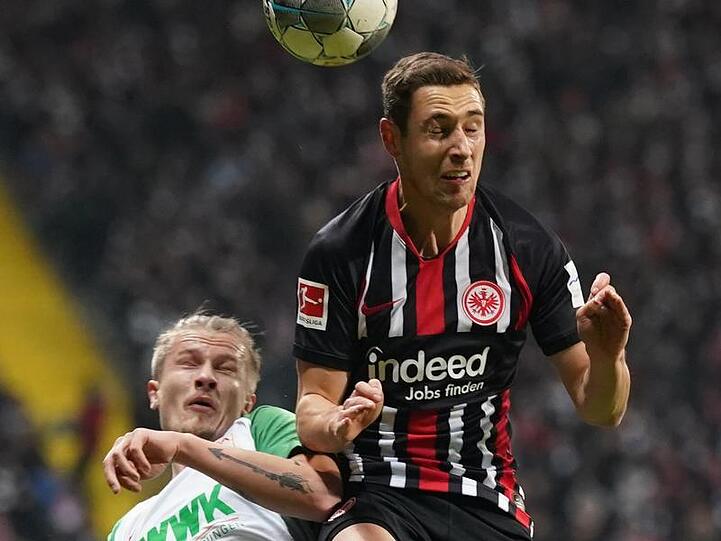 Der Augsburger Tin Jedvaj (l.) und Frankfurts Dominik Kohr kämpfen um den Ball. Foto: Thomas Frey/dpa