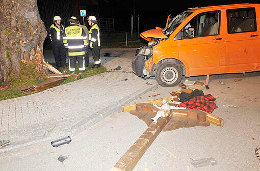 Das Holzkreuz liegt auf der Straße. Im Hintergrund die beschädigte Linde und der Pritschenwagen.