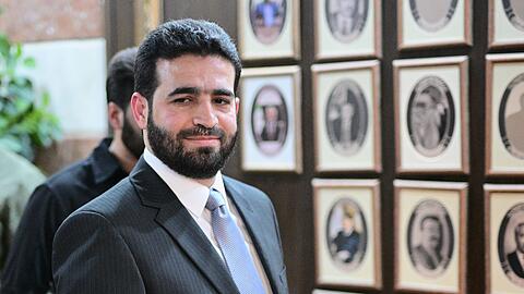 Anas Chattab ist erst seit Ende März Innenminister von Syrien. Hier steht er vor Fotos seiner Vorgänger im Amt. Die Bilder einiger Ex-Minister haben die neuen Machthaber entfernt.