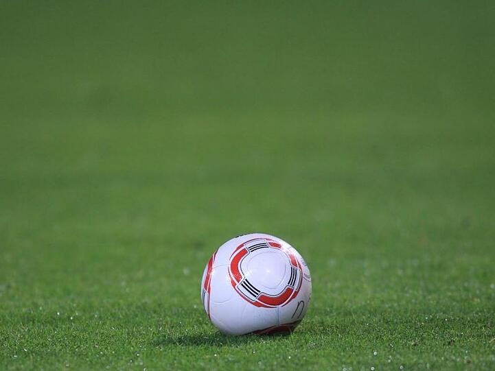 Ein Fussball liegt auf dem Rasen. Foto: picture alliance / dpa / Archivbild