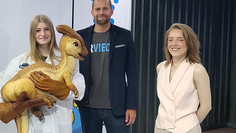 Peter Kapustin und  Assistenz der Ausstellungsleitung Vivien zusammen mit dem Dino-Baby.
