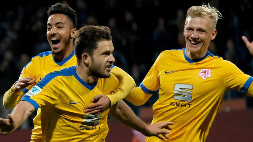 Ken Reichel (M) bejubelt sein Tor zum 1:0 für Braunschweig gegen Dynamo Dresden mit Salim Khelifi (l) und Saulo Decarli.