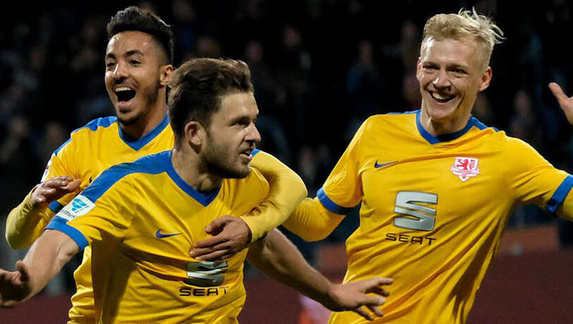 Ken Reichel (M) bejubelt sein Tor zum 1:0 für Braunschweig gegen Dynamo Dresden mit Salim Khelifi (l) und Saulo Decarli. Ken Reichel (M) bejubelt sein Tor zum 1:0 für Braunschweig gegen Dynamo Dresden mit Salim Khelifi (l) und Saulo Decarli.