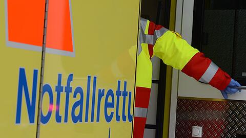 Ein Rettungsassistent steigt in einen Rettungswagen. (Symbolbild)