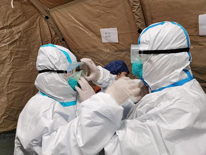 Ärzte richten sich in einem umgebauten Krankenhaus in Wuhan ihre Schutzbrillen.