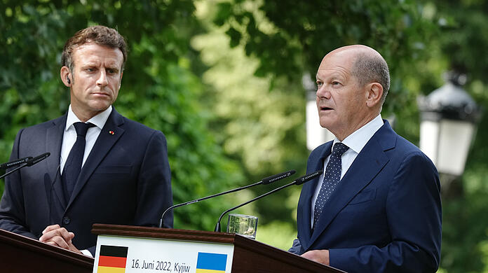 Frankreichs Präsident Emmanuel Macron (l) und Bundeskanzler Olaf Scholz (SPD) sprechen während einer gemeinsamen Pressekonferenz in Kiew.