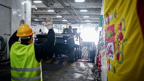 Ein Panzer wird vom Flagschiff auf ein Landeboot verladen.