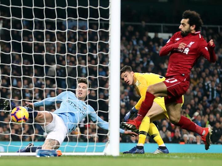 John Stones (l) von Manchester City kann einen Ball von Mohamed Salah auf der Linie klären.