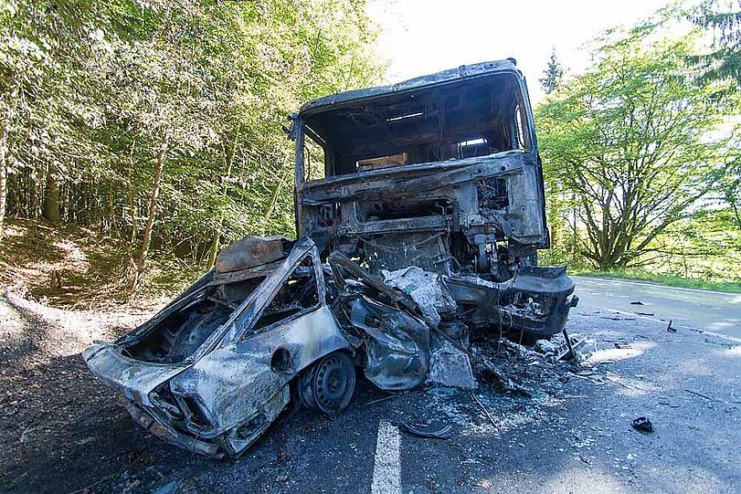 Aus bislang unbekannten Gründen kommt ein Auto auf die Gegenfahrbahn, prallt gegen einen Laster und wird unter ihn geschoben. Beide Fahrzeuge brennen komplett aus; der Autofahrer verbrennt bis zur Unkenntlichkeit.