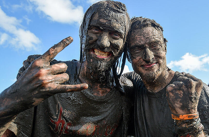 Soll ja gut für die Haut sein: Mit Schlamm überzogene Metal-Fans feiern in Wacken(Schleswig-Holstein) auf dem Festivalgelände.