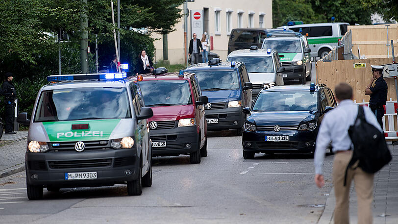 Ein Fahrzeugkonvoi mit Angeklagten kommt zum Gebäude des Oberlandesgerichts.