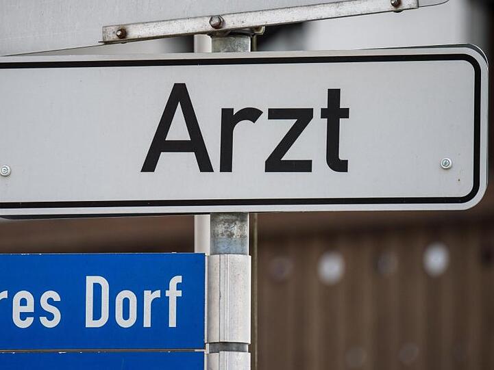 Ein Hinweisschild mit der Aufschrift "Arzt" ist in einem kleinen Ort in Bayern angebracht. Foto: Armin Weigel/Archiv