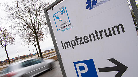 Ein Schild am Straßenrand weist den Besuchern den Weg zum Impfzentrum an der Messe Riem.