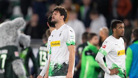 Mönchengladbachs Spieler stehen nach der bitteren Niederlage in Wolfsburg enttäuscht auf dem Platz.