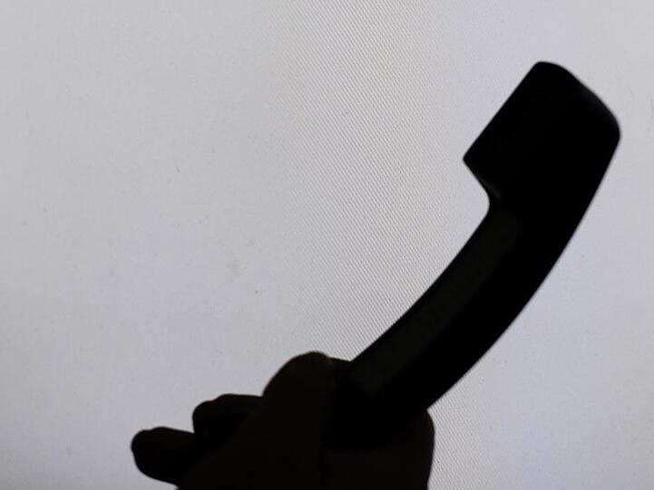Ein Mann hält einen Telefonhörer. Foto: Armin Weigel/dpa/Archivbild