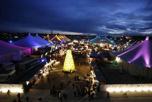 Winterliches Farbenspiel: Ein Blick auf das abendliche Tollwood Winterfestival 2008. In der Mitte: &bdquo;Der gelbe Sackbaum&ldquo; von Dorothea Seror.
