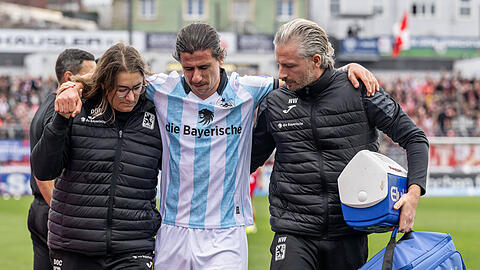 Gestützt von Teamärztin Dr. Monika Mrosek (l.) und Physiotherapeut Nick Wurian (r.) muss Mittelfeld-Löwe Tunay Deniz gegen Energie Cottbus nach 63 Minuten vorzeitig vom Feld.