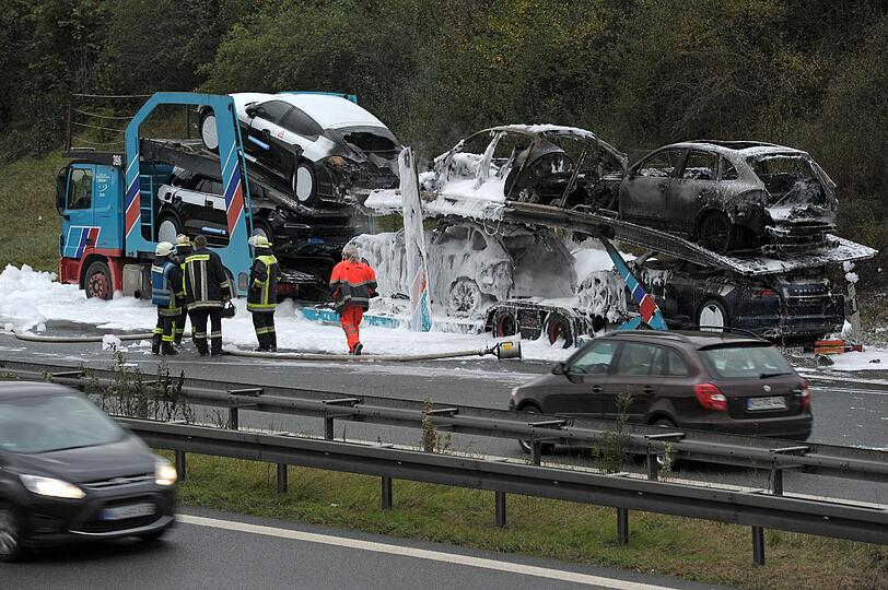 Völlig verbrannt und voller Lösch-Schaum: Auf der A9 bei Bayreuth ist ein Autotransporter in Flammen aufgegangen. Geladen hatte der Lastzug hochwertige Porsche Cayenne und Panamera. Die Bilder.