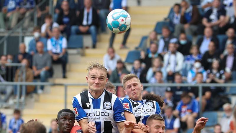 Bielefelds Amos Pieper (oben, l) setzt sich im Kopfballduell gegen Hoffenheims Diadie Samassekou (unten, l-r) und Pavel Kaderabek durch.