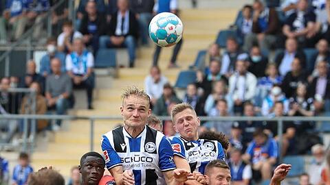 Bielefelds Amos Pieper (oben, l) setzt sich im Kopfballduell gegen Hoffenheims Diadie Samassekou (unten, l-r) und Pavel Kaderabek durch.