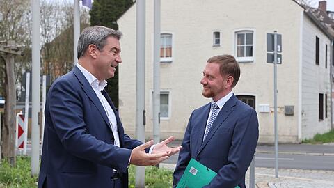 Markus Söder (l, CSU) und Michael Kretschmer (CDU) reden vor einer Kabinettssitzung miteinander.