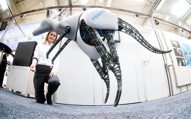 Informatikerin Nadine Kärcher lässt auf der Hannover Messe in Hannover (Niedersachsen) mit einem Steuerelement an ihrem Arm ein Känguru "Bionic Kangaroo" der Firma Festo springen. Die Industriemesse findet vom 7. bis 11. April 2014 statt.