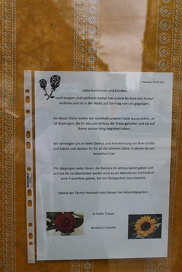 ...klebt ein mit Blumen verzierter Zettel, den die Angehörigen der Verstorbenen hinterlassen haben.