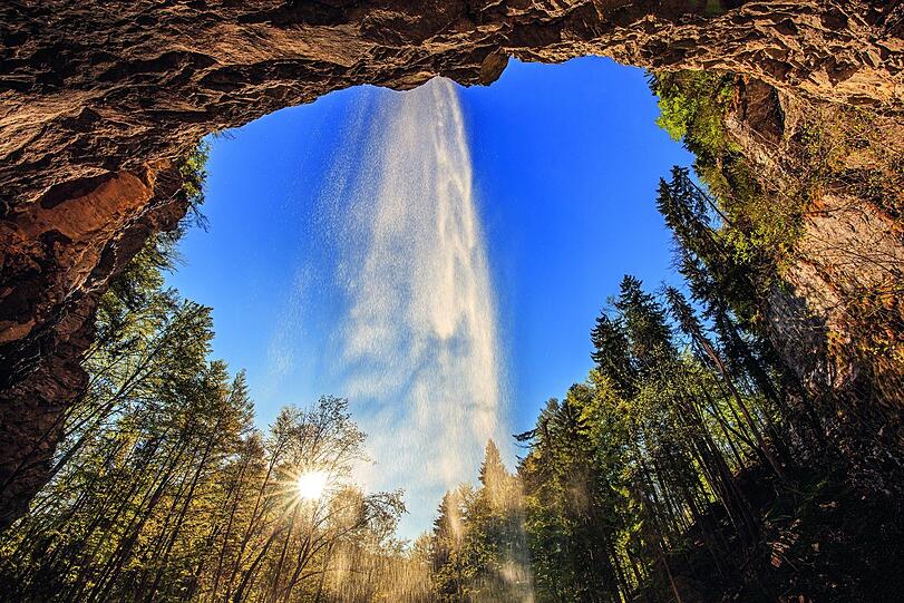 Sprühschleier-Tanz: Der Schloßrinn-Wasserfall bei Aschau ist einer der wenigen, der von hinten begehbar ist.