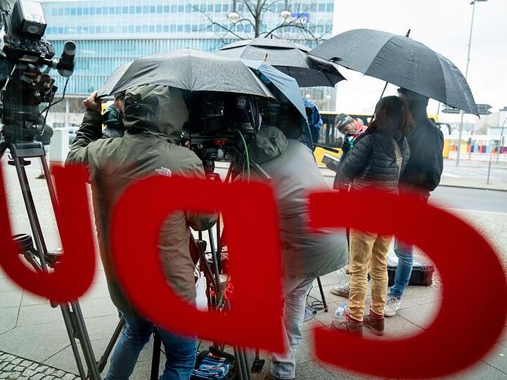 Medienvertreter warten im Regen vor der CDU-Zentrale, dem Konrad-Adenauer-Haus. Foto: Kay Nietfeld/dpa